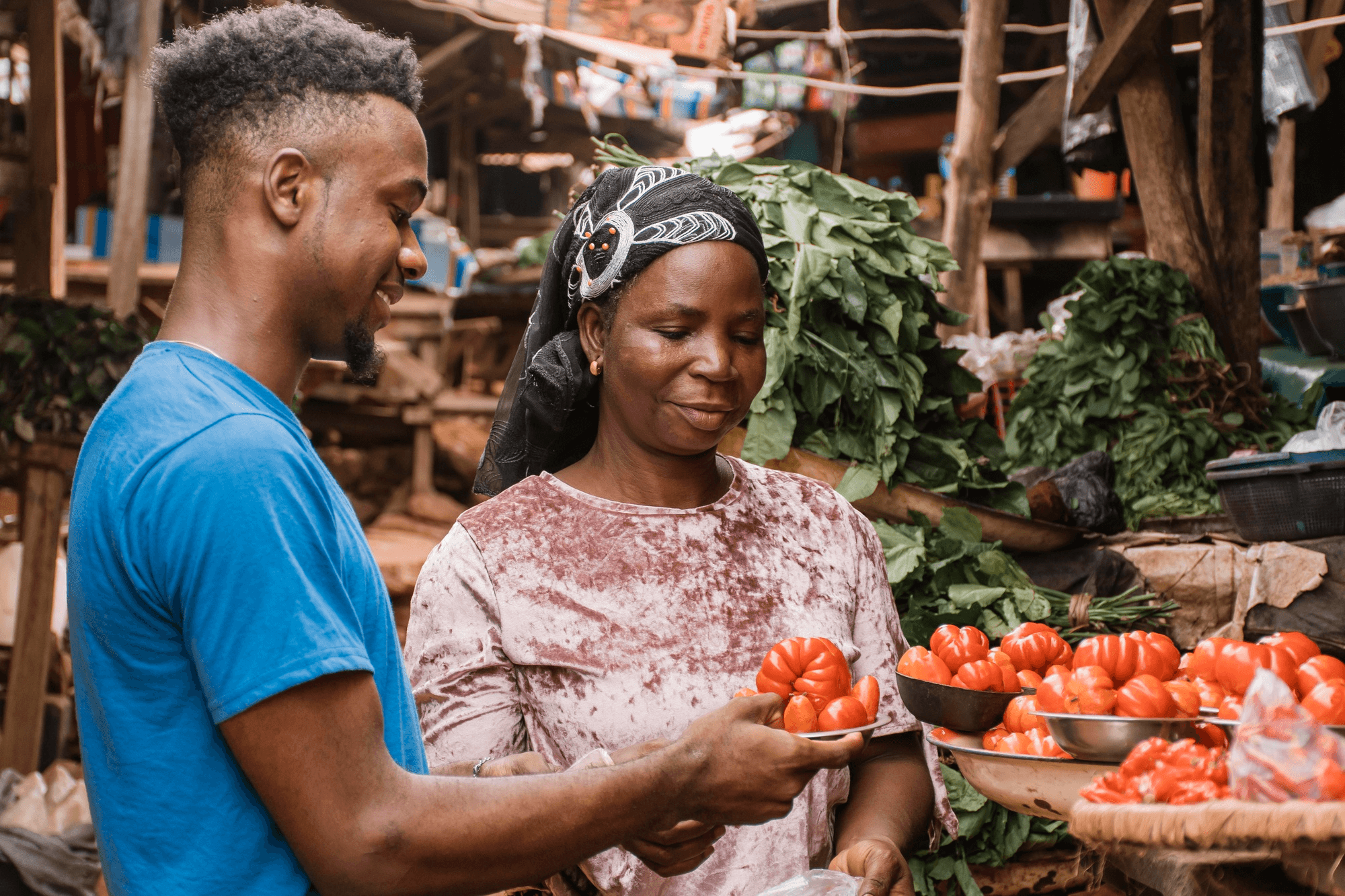A researcher speaking with a trader at a fresh-produce market